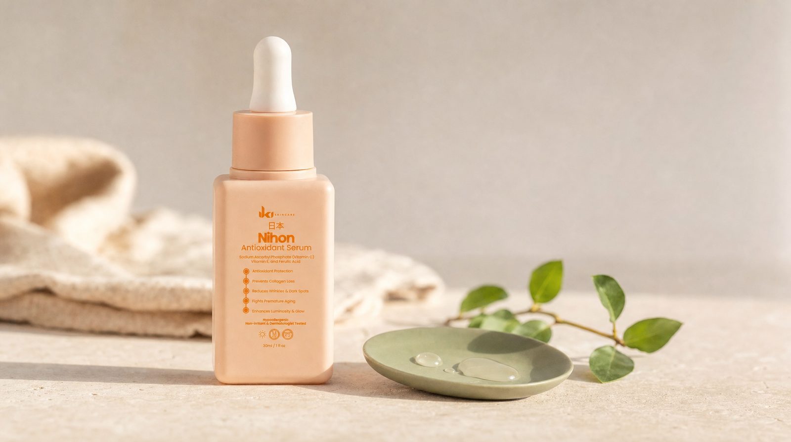 Nihon Antioxidant Serum by IKI on a cream stone surface beside a sage-green ceramic dish with drops of serum and a sprig of green leaves